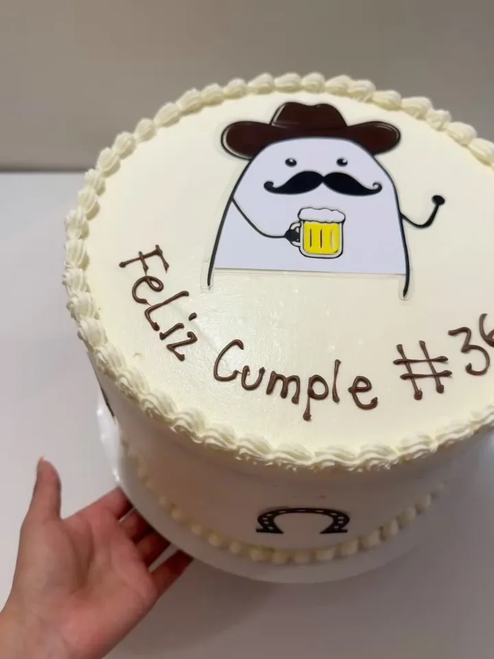 White buttercream birthday cake with a playful illustrated beer design