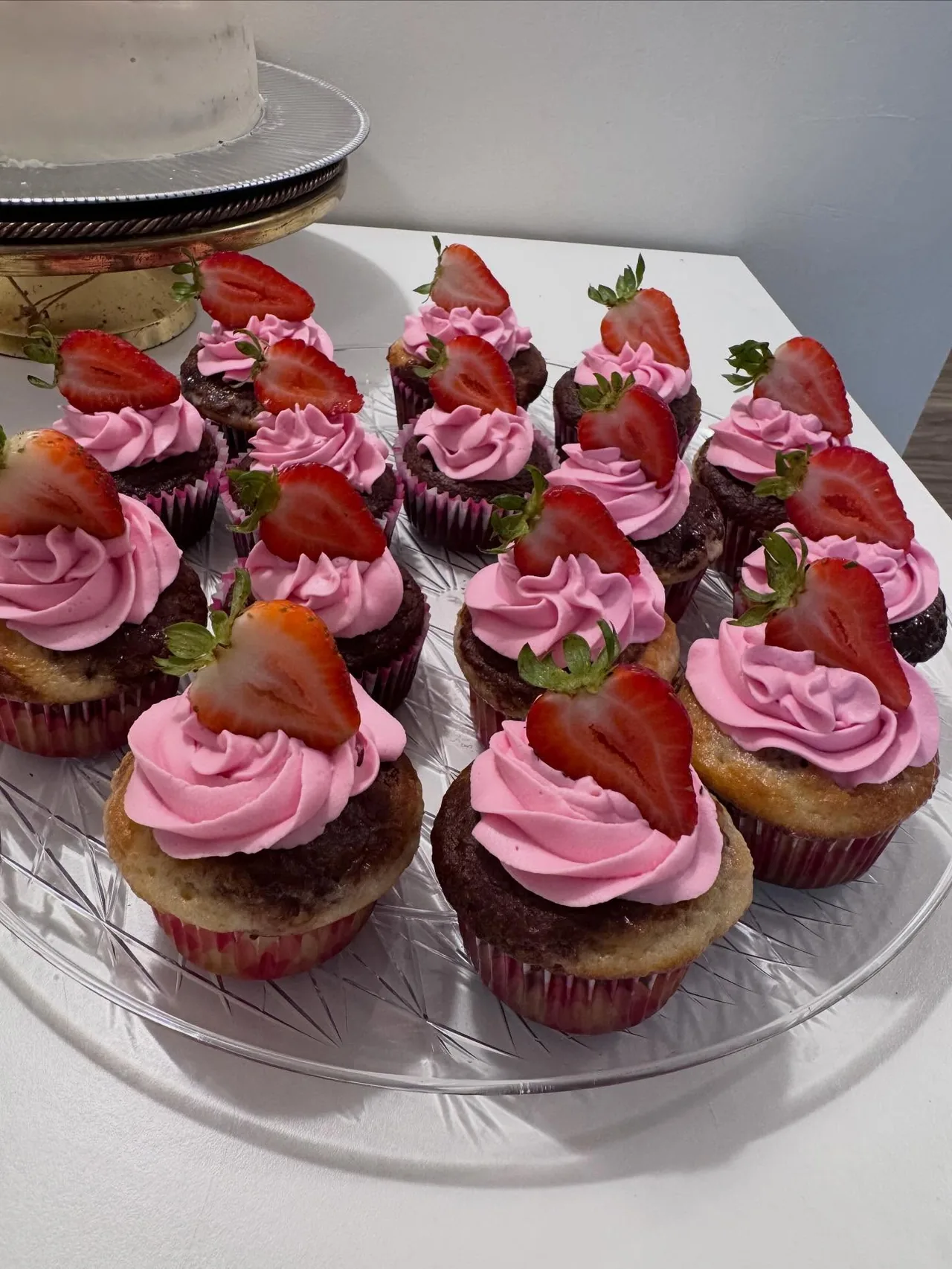 Chocolate and vanilla cupcakes with pink buttercream rosettes and strawberries
