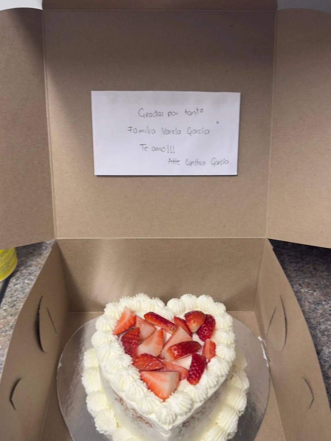 Fresh strawberry cake boxed with a handwritten thank-you note